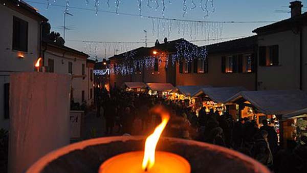 Candela accesa e mercatino natalizio nel borgo di Candelara