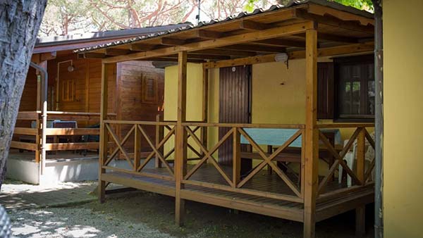 bungalow in legno con veranda immerso nel verde