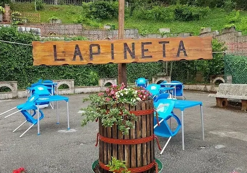 Insegna Hotel La Pineta con tavoli all’aperto