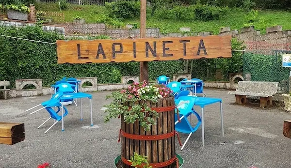 Insegna Hotel La Pineta con tavoli all’aperto