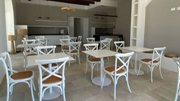 Sala colazione elegante con tavoli bianchi e arredo minimal