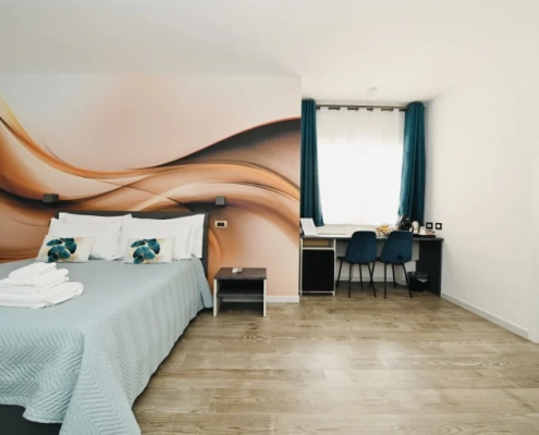 Ampia camera da letto moderna con scrivania e arredamento curato presso Vimini