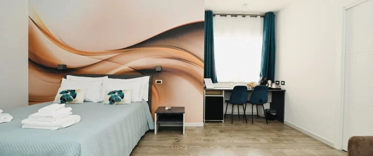 Ampia camera da letto moderna con scrivania e arredamento curato presso Vimini