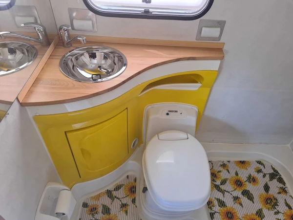 Bagno camper con arredo giallo e lavandino